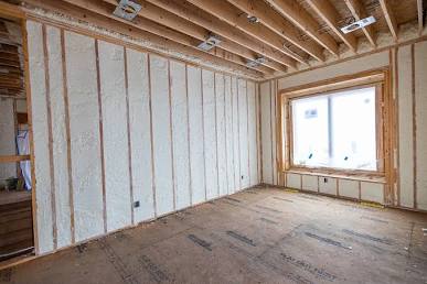 open cell foam expanding between wall studs.